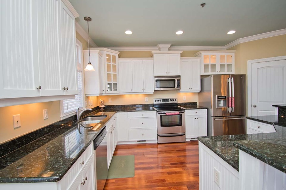 kitchen with granite counters and stainless steel appliances. refrigerator, stove, microwave hood, and dishwasher